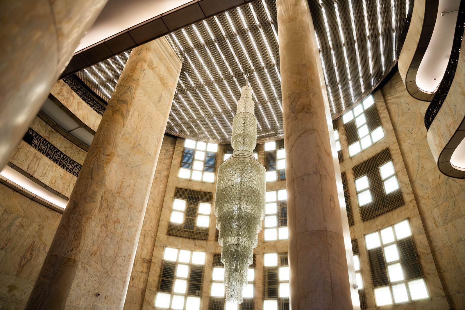 Grand chandelier within a marble architectural interior