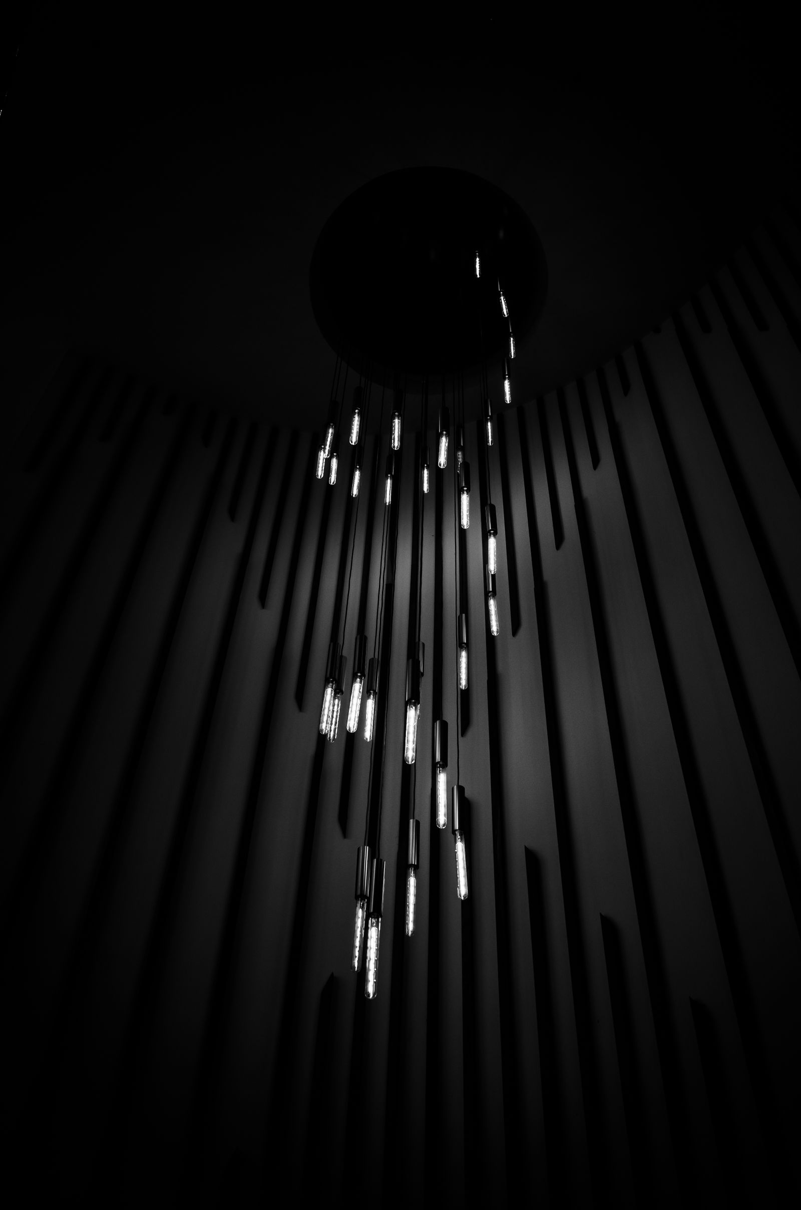 Modern suspended chandelier with a narrow sculptural silhouette