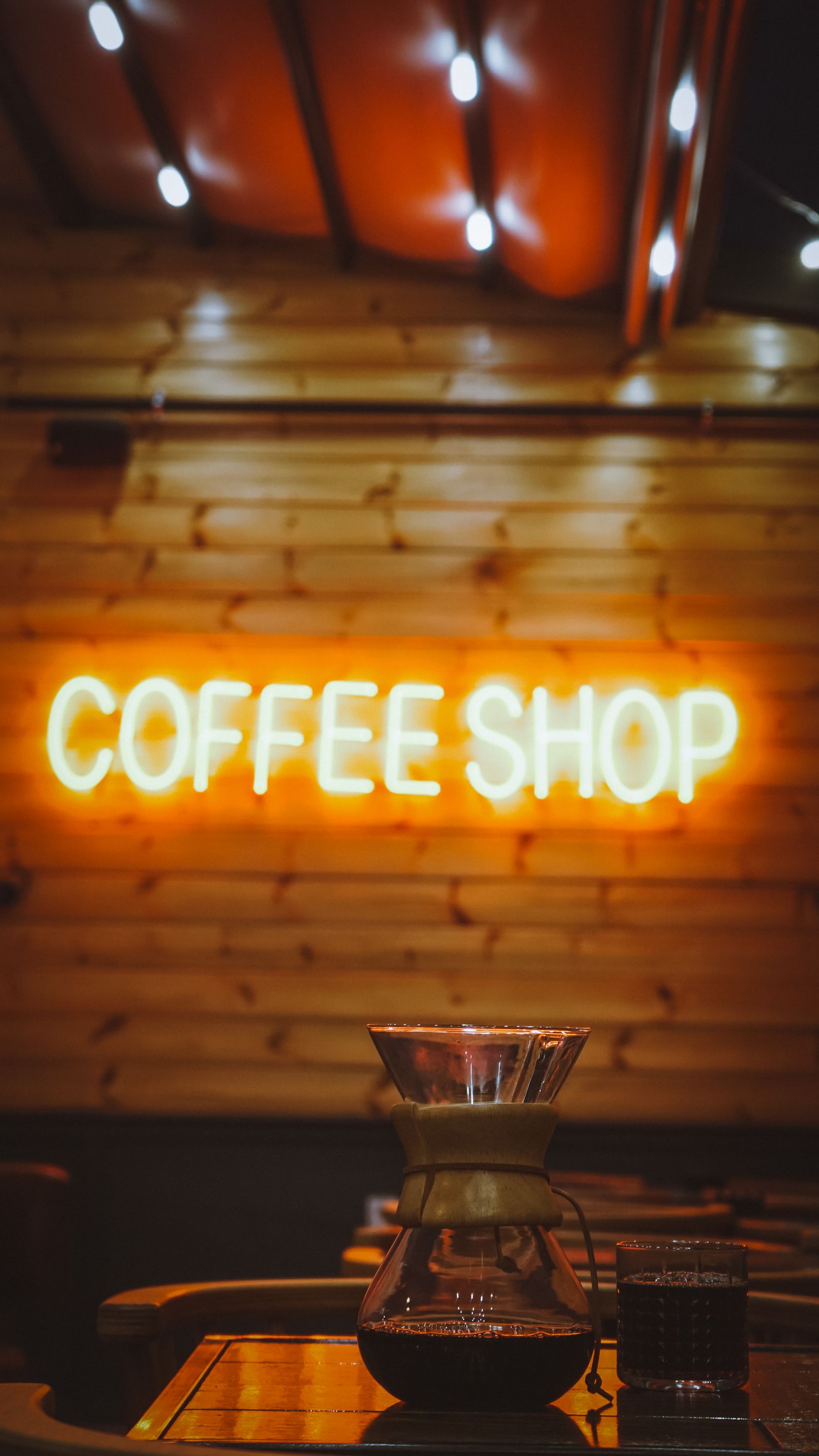 Custom illuminated coffee shop lettering on an interior feature wall