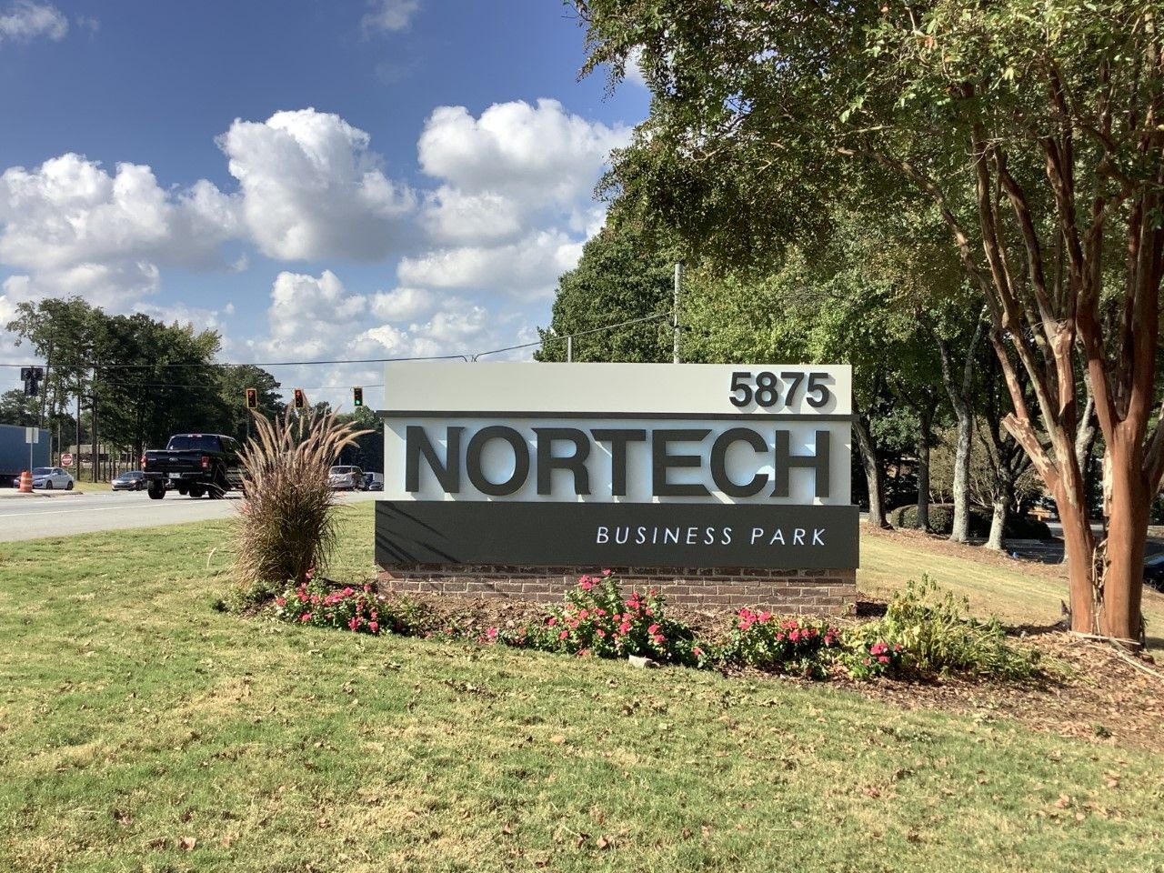Exterior blade sign mounted beside a commercial entrance